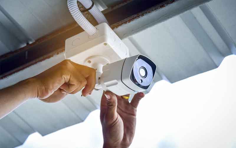 hands of male technician installing cctv outdoors