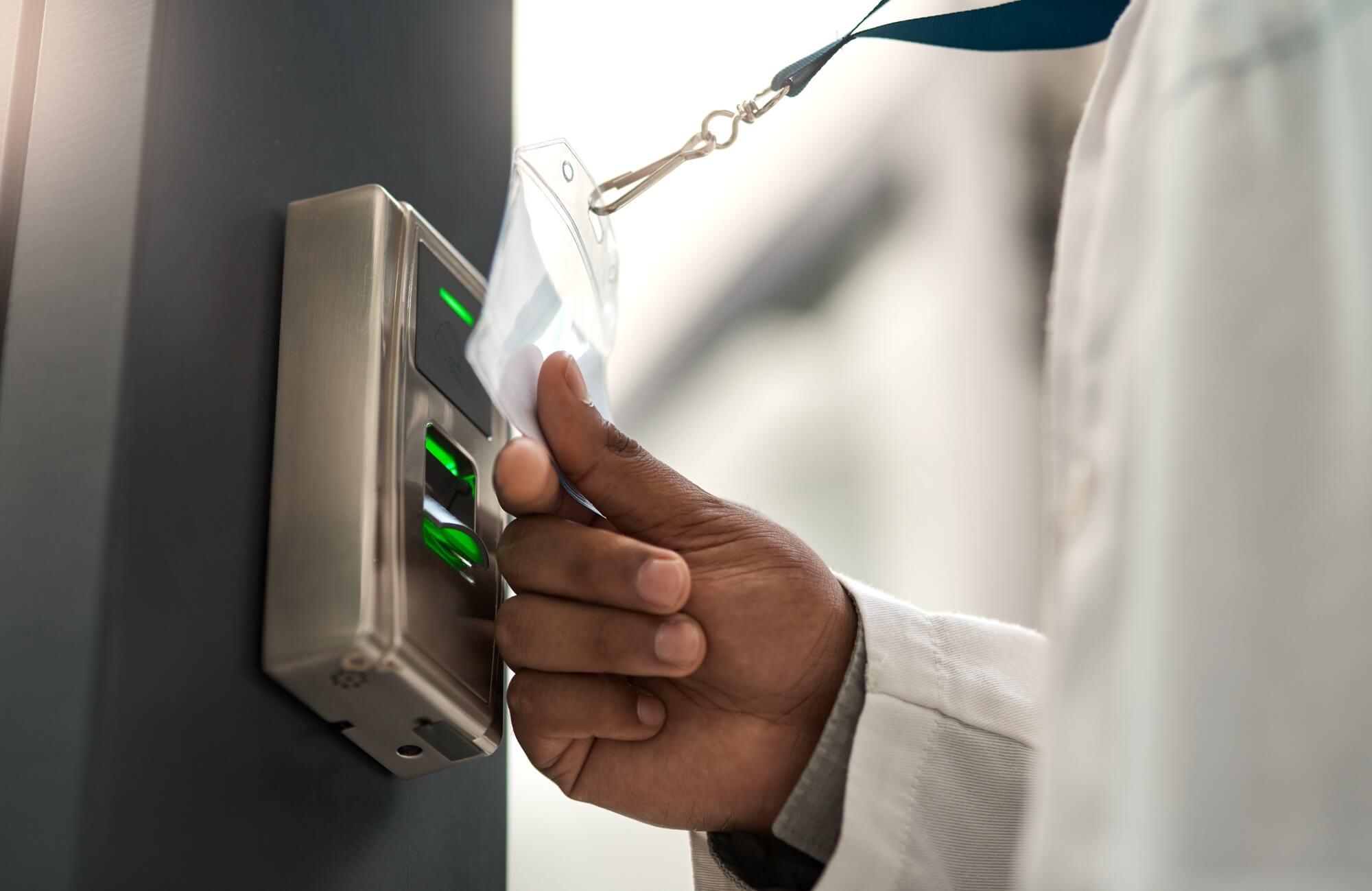 man in lab coat using an access card to gain entry at a door