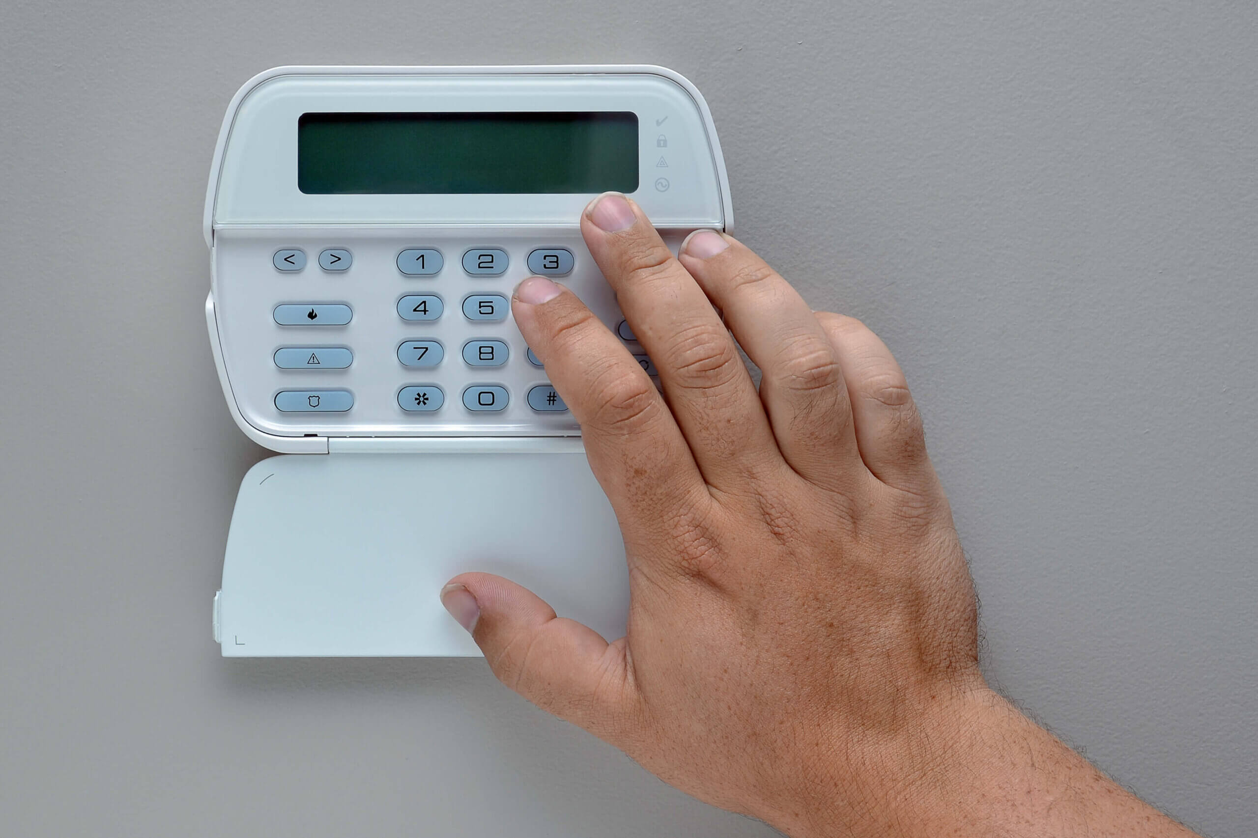 hand of male using home security panel